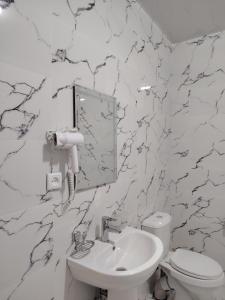 a white bathroom with a toilet and a sink at Парк апарт-отел in Namangan +31 photos