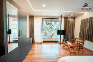 a room with a bed and a table and a chair at Velmora Luxe Residences in Madurai