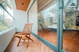 a wooden chair sits on the balcony of a house at Velmora Luxe Residences in Madurai
