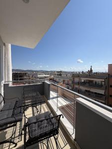 a balcony with chairs and a view of a city at Kali's home in Komotini