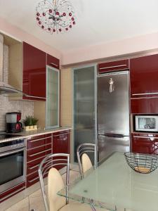 a kitchen with red cabinets and a glass table at Kali's home in Komotini