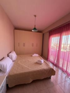 a bedroom with a large bed and two windows at Kali's home in Komotini