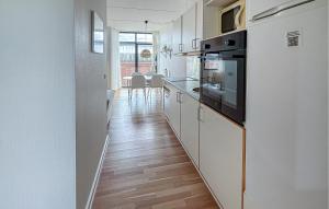 a kitchen with white cabinets and a wooden floor at Fanø Bad, Lejl 56 in Fanø
