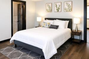 a bedroom with a large white bed and two lamps at Spacious Private Queen Studio Near Downtown in Muskegon