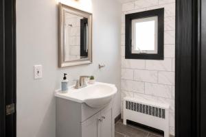 a white bathroom with a sink and a mirror at Spacious Private Queen Studio Near Downtown in Muskegon +28 photos