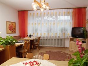 uma sala de estar com uma mesa de jantar e uma televisão em Gästehaus Brunner em Egglfing