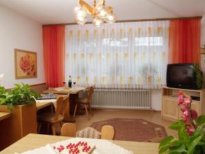 a living room with a dining table and a television at Gästehaus Brunner in Egglfing