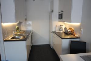 a small kitchen with white cabinets and a sink at Jaakonkatu City Apartment in Rovaniemi