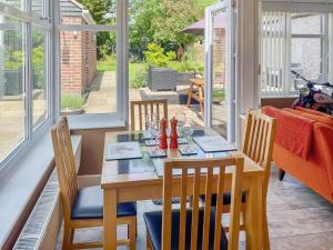 a dining room with a wooden table and chairs at Pinecote in Bottesford +17 photos