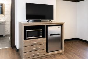 a entertainment center with a television and a refrigerator at Private King Studio Close To The Action in Muskegon