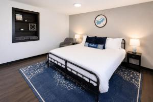 a bedroom with a large bed with a blue rug at Private King Studio Close To The Action in Muskegon