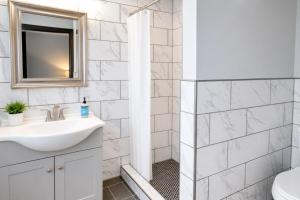 a white bathroom with a sink and a shower at Private King Studio Close To The Action in Muskegon