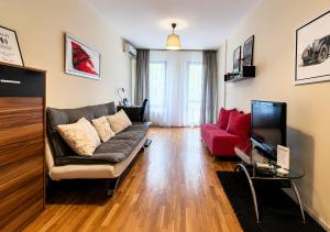 a living room with a couch and a red couch at City Apartments in Sofia