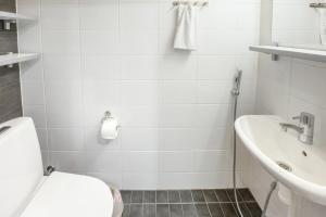a white bathroom with a toilet and a sink at Ruka Ski Chalets in Ruka