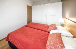 a bedroom with a bed with a red blanket at Ruka Ski Chalets in Ruka