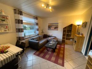 a living room with a couch and a table at Bluhm EG in Wangerland