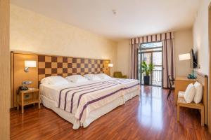 ein Schlafzimmer mit einem großen Bett mit einem Schachbrett-Kopfteil in der Unterkunft Hotel Duran in Figueres + 35 Fotos