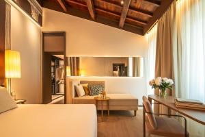 a room with a bed and a couch and a table at Domus Teatro di Pompeo in Rome