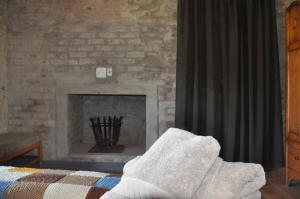 a living room with a fireplace and a bed at Schuilhoek Cottage - Your perfect hide away! in Calitzdorp