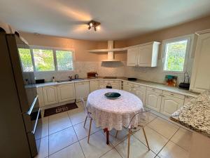 a kitchen with a table with a table cloth on it at Villa à Pyla-sur-Mer avec piscine in La Teste-de-Buch