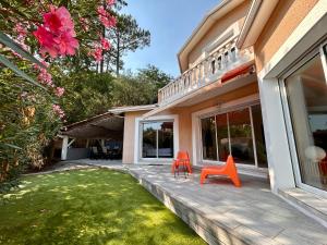 two orange chairs sitting on a porch of a house at Villa à Pyla-sur-Mer avec piscine in La Teste-de-Buch