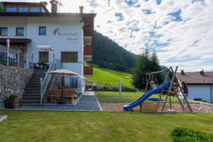 a playground in front of a house with a slide at Ferienhof Blaas in Malles Venosta