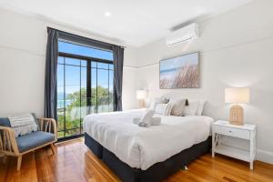 a bedroom with a bed and a chair and a window at Marram House - Views in Marengo in Marengo