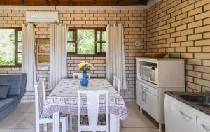 a kitchen with a table with a vase of flowers on it at Hospedaria Nativa in Praia do Rosa