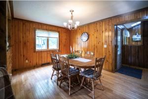 a dining room with a table and chairs and a clock at Agape Aldea in Jamestown