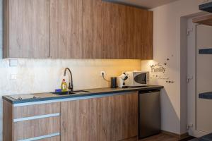 a kitchen with wooden cabinets and a microwave at Mama Boutique Apartment in Krušetnica