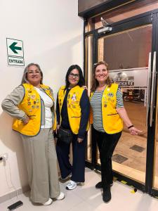 three women wearing yellow jackets posing for a picture at ISIS HOTEl in Tumbes