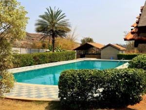 a swimming pool in a yard with a palm tree at Valley Vibes in Rāmanagaram +16 photos