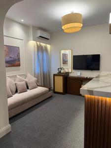 a living room with a couch and a flat screen tv at IOS Village & Hotels in El Alamein