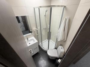 a bathroom with a shower and a toilet and a sink at Zen Rooms in Suceava +12 photos