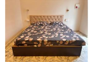 a bed with a brown comforter and pillows on it at FabHotel Hill View Cottages in Arpora