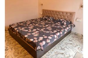 a bedroom with a bed with pink flowers on it at FabHotel Hill View Cottages in Arpora
