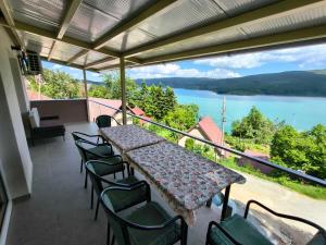a table and chairs on a balcony with a view of a lake at Villa Nena in Mavrovi Anovi
