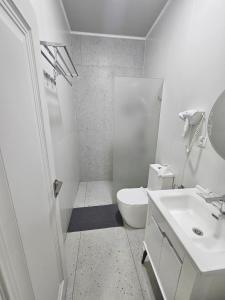 a white bathroom with a toilet and a sink at BOG'DON GRAND Hotel in Tashkent +54 photos