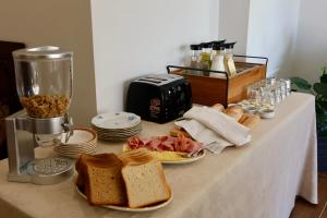 a table with bread and a toaster and a pile of food at Balzanija Boutique Accommodation in Balzan +49 photos