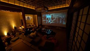 a living room with a large projection screen at Ikada in Amami