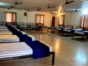 a row of beds in a large room at Valley Vibes in Rāmanagaram