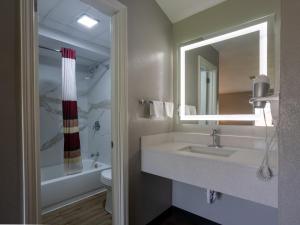 a bathroom with a sink and a mirror at Colonial Brick Inn & Suites in New Milford +43 photos