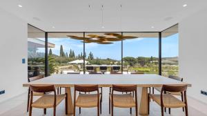 a dining room with a large white table and chairs at Villa Trois-Pins in Ramatuelle