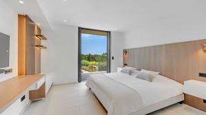 a bedroom with a large bed and a large window at Villa Trois-Pins in Ramatuelle +11 photos