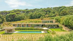 an exterior view of a house with a swimming pool at Villa Trois-Pins in Ramatuelle