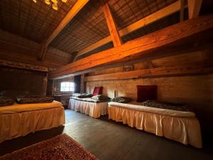 a room with three beds in a wooden building at Anno 1782 Unique Romantic Glamping at the Manors Historic Barn in Arnager