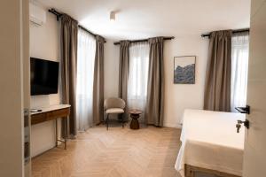 a hotel room with a bed and a desk and a television at Villa Mater in Trogir