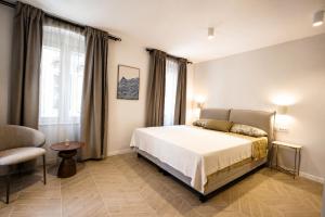 a bedroom with a bed and a chair and a window at Villa Mater in Trogir
