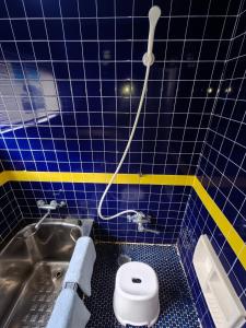 a blue tiled bathroom with a toilet and a sink at Ikada in Amami +12 photos