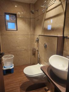 a bathroom with a toilet and a sink at Hotel Suncity Residency in Kālundri +33 photos